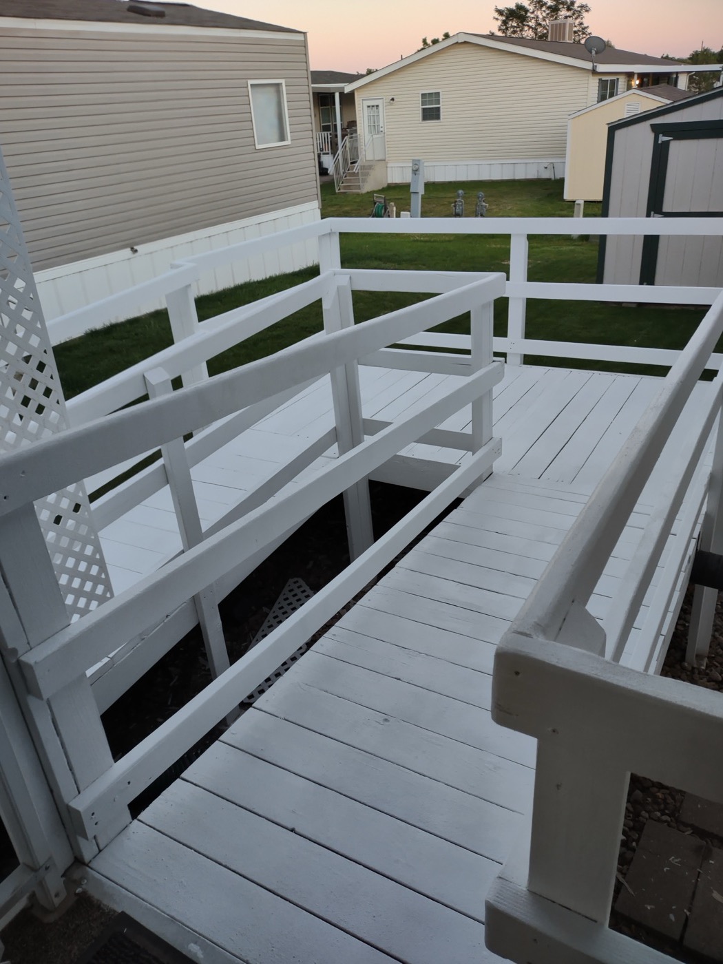 Custom-built white wooden ramp and deck on a manufactured home