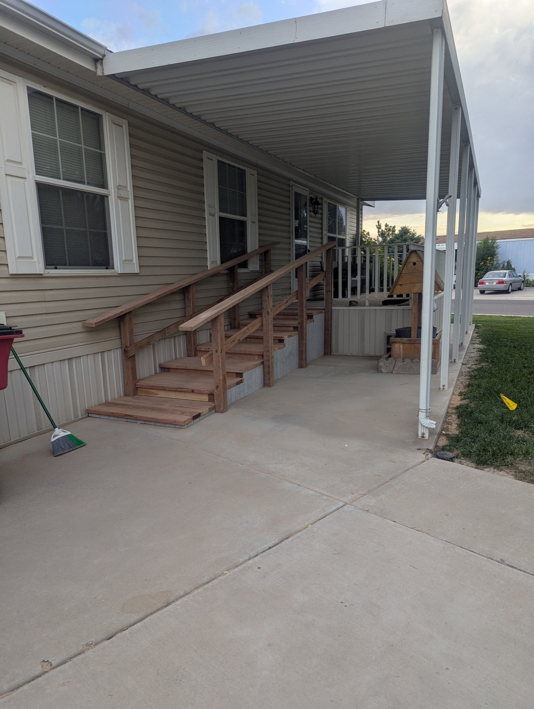 Wide-tread wooden access stairs with double handrails on a manufactured home